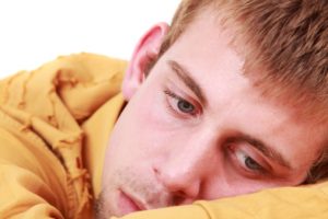 Sad man laying head on his arms